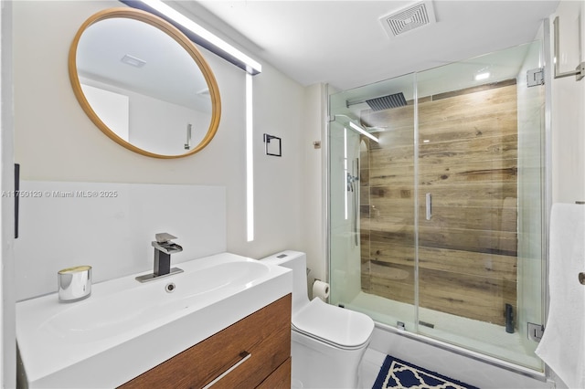 bathroom featuring toilet, a stall shower, vanity, and visible vents