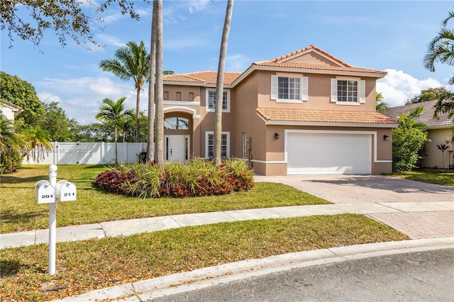 view of front facade with an attached garage, fence, decorative driveway, stucco siding, and a front yard