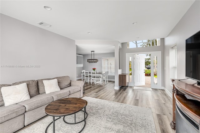 living room with recessed lighting, light wood-style flooring, and baseboards