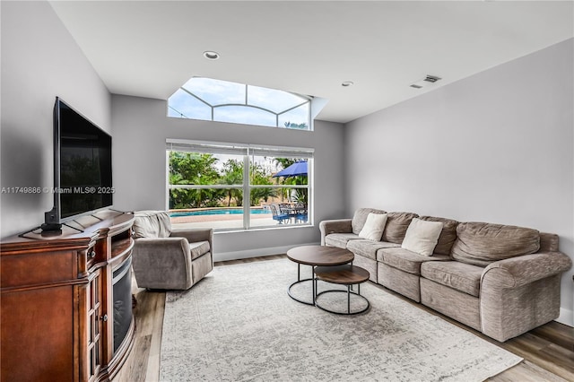 living area with visible vents and wood finished floors