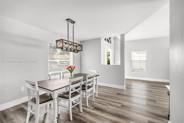 dining area with dark wood-style floors and baseboards