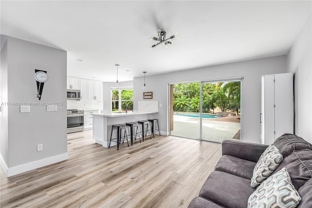 living area featuring light wood-style floors and baseboards