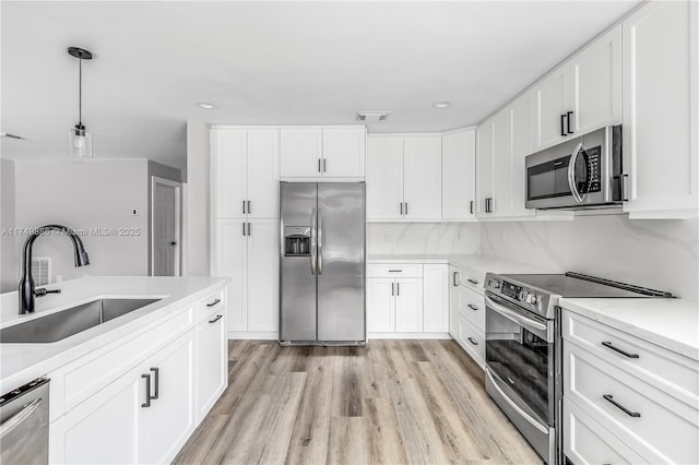 kitchen with a sink, stainless steel appliances, and light countertops