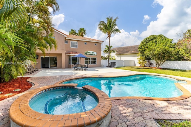 view of pool with central AC unit, a patio area, a fenced backyard, and a pool with connected hot tub