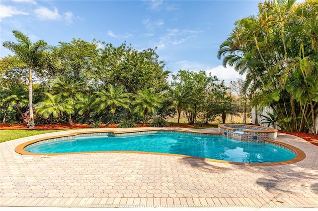 view of swimming pool featuring a patio and a pool with connected hot tub