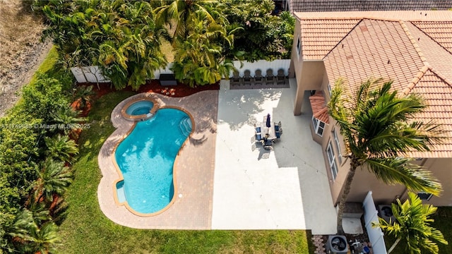 view of swimming pool featuring a pool with connected hot tub and a patio