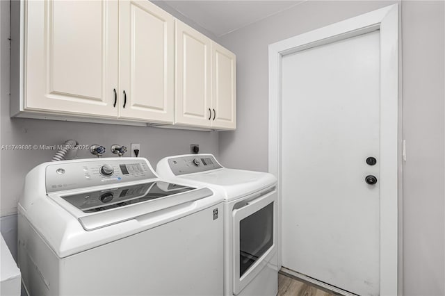 laundry area with cabinet space, washer and clothes dryer, and wood finished floors