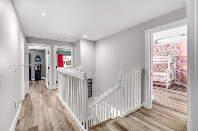 hallway with light wood-style floors, recessed lighting, an upstairs landing, and baseboards