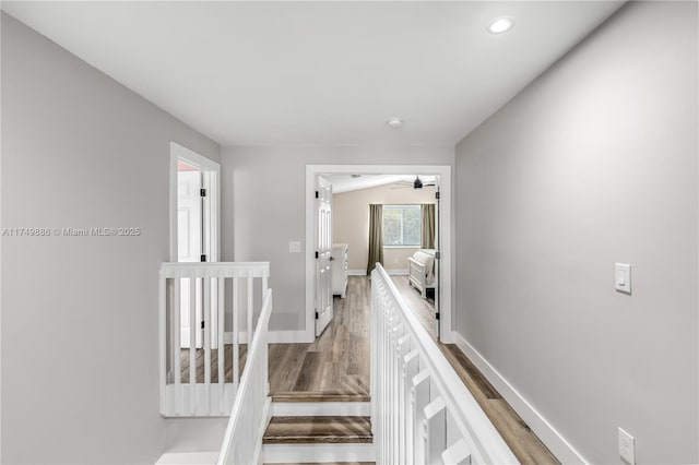 hall featuring recessed lighting, wood finished floors, an upstairs landing, and baseboards