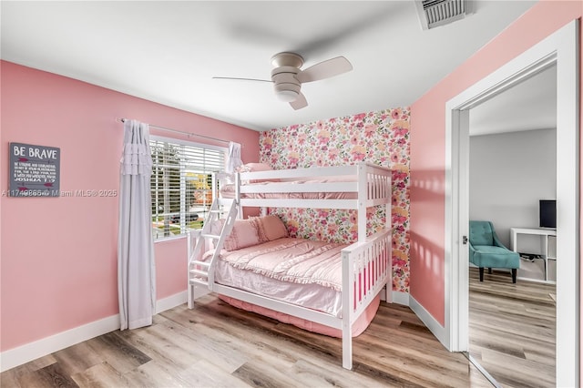 bedroom with visible vents, baseboards, ceiling fan, and wood finished floors