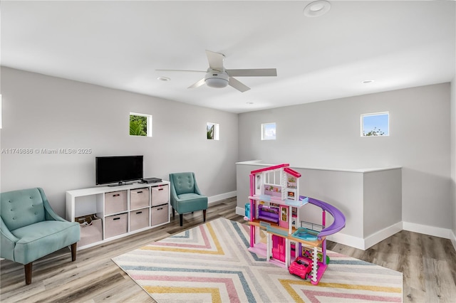 game room featuring a healthy amount of sunlight, light wood-type flooring, and baseboards