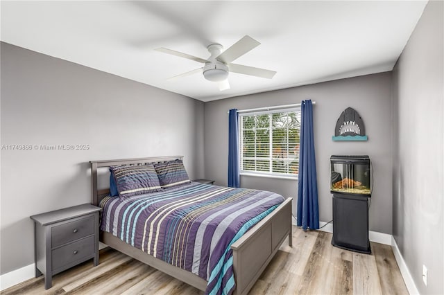 bedroom featuring light wood finished floors, ceiling fan, and baseboards