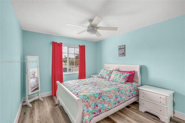 bedroom featuring a ceiling fan, light wood-style flooring, and baseboards