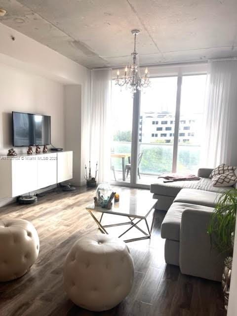 living area featuring wood finished floors and an inviting chandelier