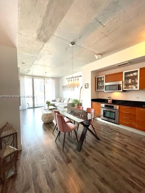 dining area featuring dark wood-style floors, a wall of windows, and visible vents