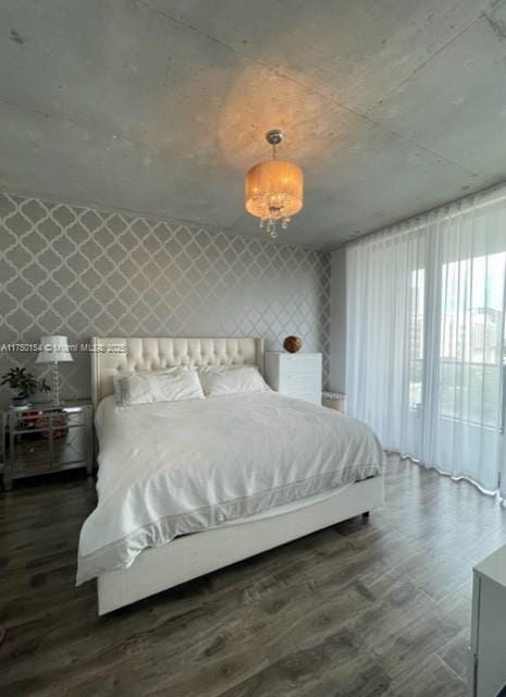 bedroom featuring wallpapered walls and dark wood finished floors