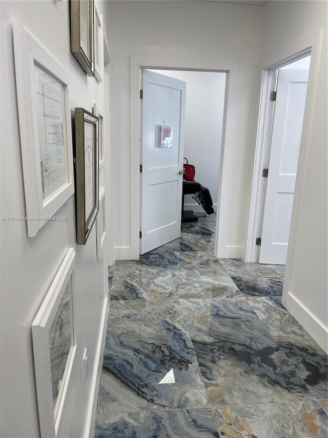 hallway featuring marble finish floor