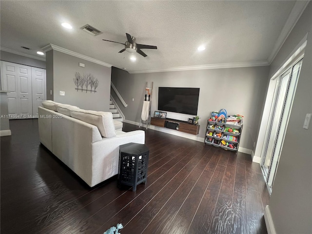 living area featuring baseboards, visible vents, ornamental molding, dark wood-type flooring, and a textured ceiling