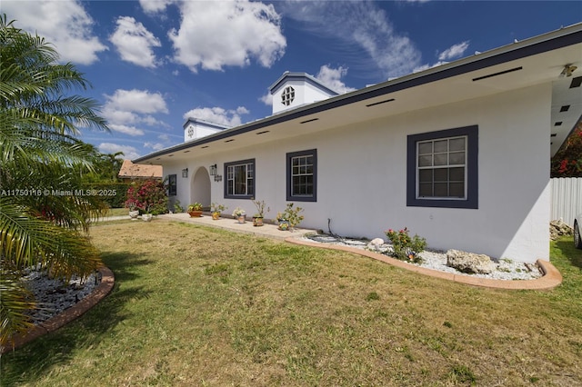 view of front of property featuring a front lawn and stucco siding