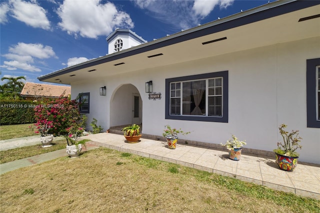 view of front of home featuring stucco siding and a front yard