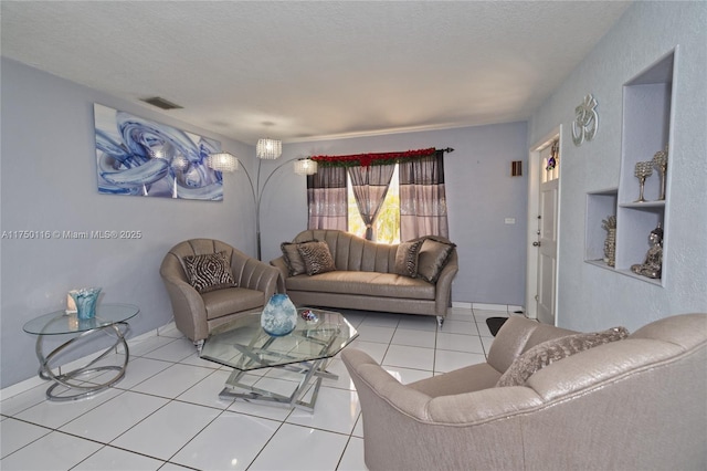 living area featuring light tile patterned floors, a textured ceiling, and visible vents