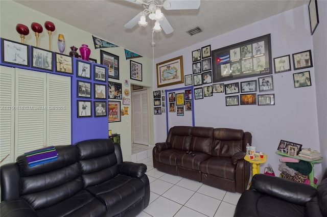 living area with ceiling fan, visible vents, a textured ceiling, and light tile patterned flooring