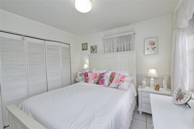 bedroom with a closet and light tile patterned flooring