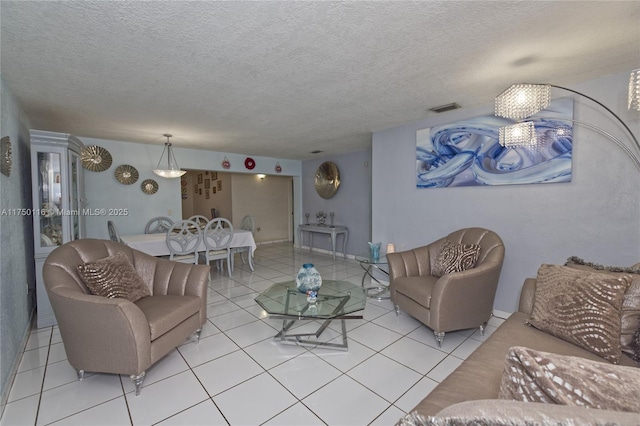 living area featuring a textured ceiling, visible vents, and light tile patterned floors