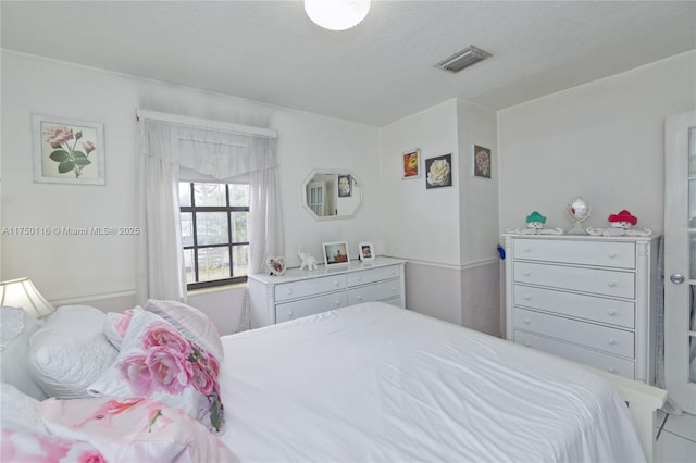 bedroom featuring visible vents and a textured ceiling