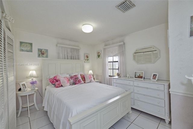 bedroom with light tile patterned floors and visible vents