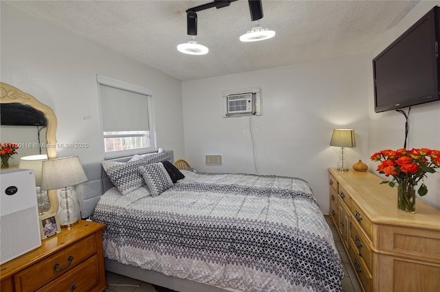 bedroom featuring dark tile patterned floors, ceiling fan, a textured ceiling, and a wall mounted AC