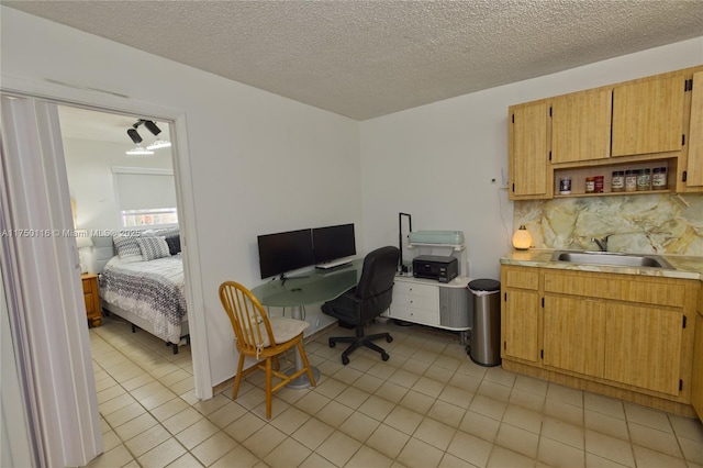 office featuring a textured ceiling, a sink, and light tile patterned floors
