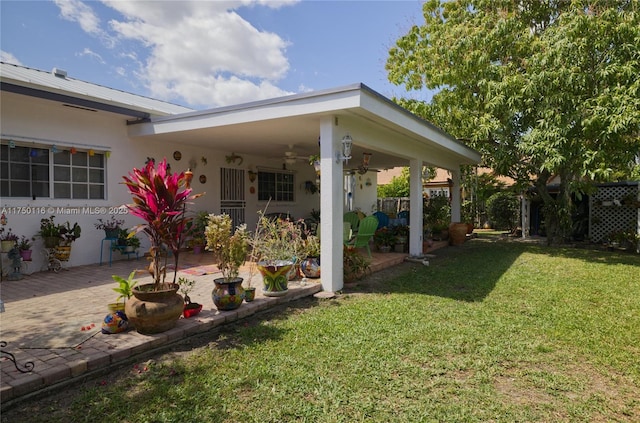 view of yard with ceiling fan and a patio