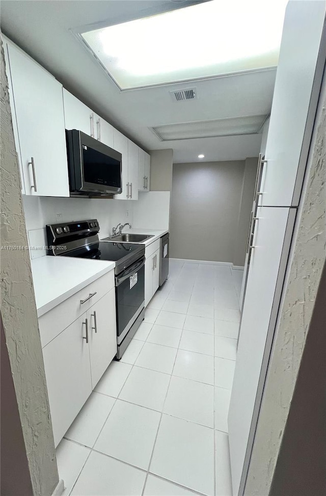 kitchen featuring light tile patterned floors, visible vents, stainless steel appliances, light countertops, and a sink