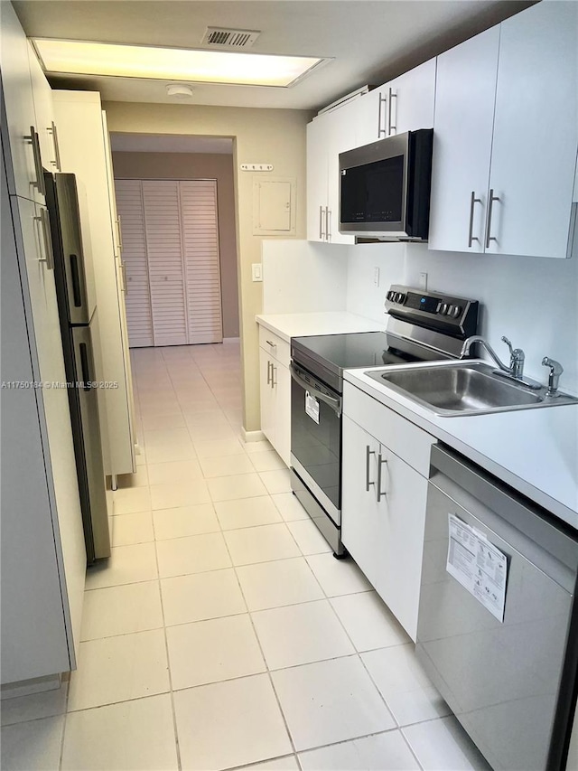 kitchen featuring visible vents, appliances with stainless steel finishes, light countertops, and a sink