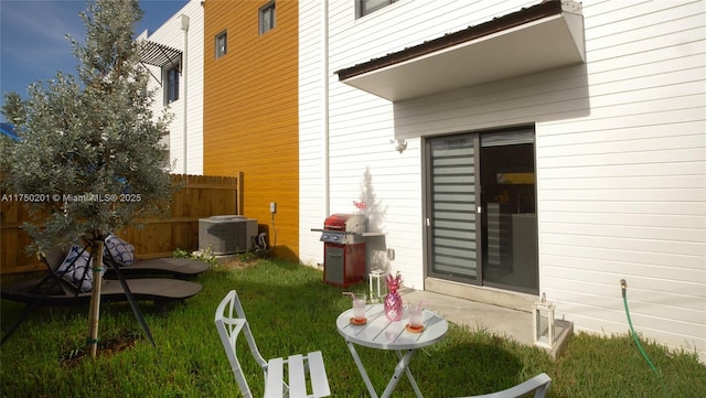 view of property exterior with central AC, a lawn, and fence