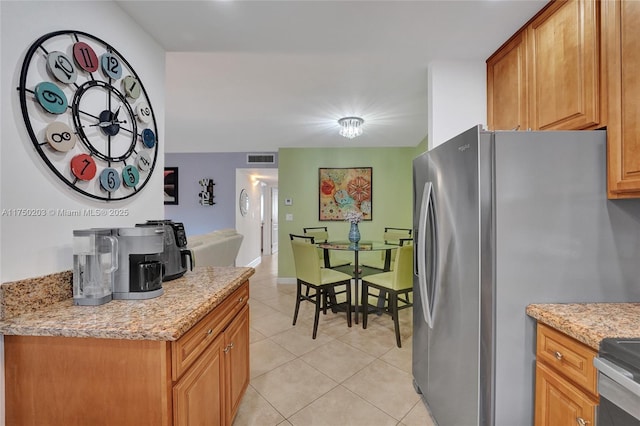 5300 Washington St Unit I203, Hollywood, FL 33021 - kitchen with light stone counters, light tile patterned flooring, visible vents, and freestanding refrigerator