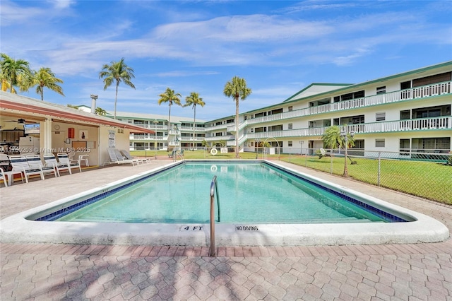 community pool with fence and a patio