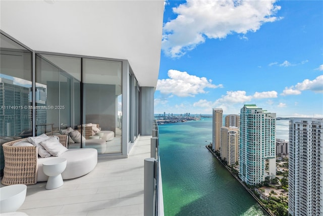 balcony featuring a water view and a city view