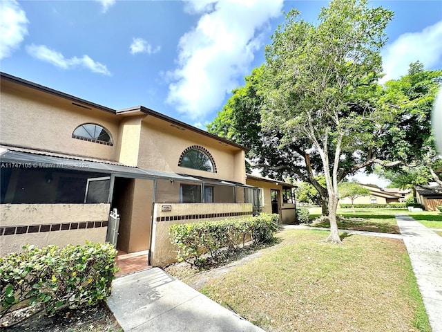 exterior space with a lawn and stucco siding