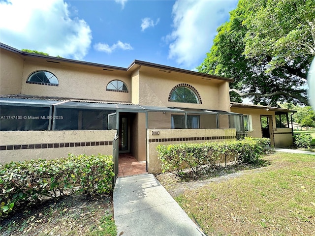 view of front facade featuring a front yard and stucco siding