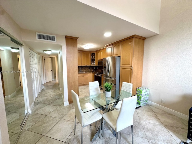 dining space with light tile patterned floors, baseboards, and visible vents