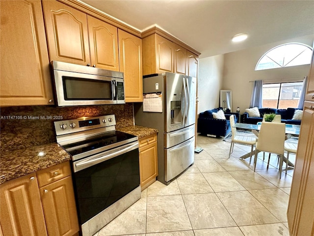 kitchen with backsplash, appliances with stainless steel finishes, open floor plan, light tile patterned flooring, and dark stone countertops