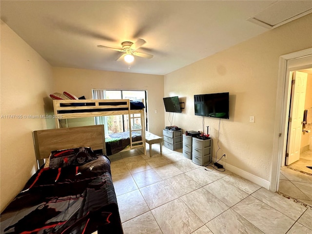 bedroom featuring attic access, light tile patterned flooring, baseboards, and a ceiling fan