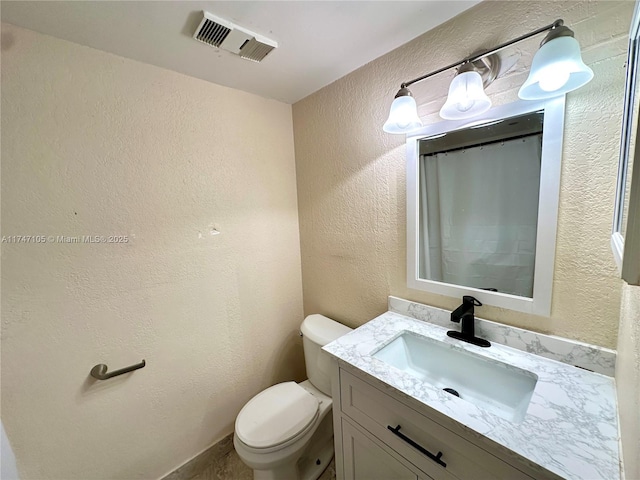 full bath with toilet, a textured wall, vanity, and visible vents