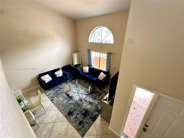 living area featuring light tile patterned floors and baseboards