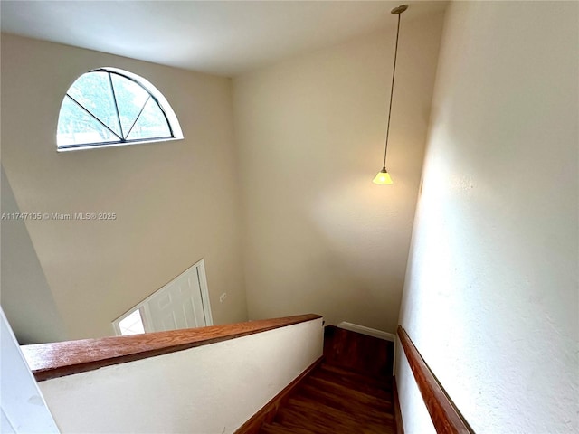 stairway with wood finished floors and baseboards