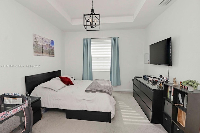 bedroom featuring a tray ceiling, visible vents, an inviting chandelier, light carpet, and baseboards