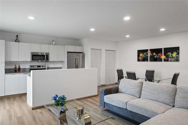 living room with recessed lighting and light wood-style floors