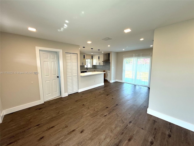 unfurnished living room featuring visible vents, baseboards, dark wood finished floors, and recessed lighting